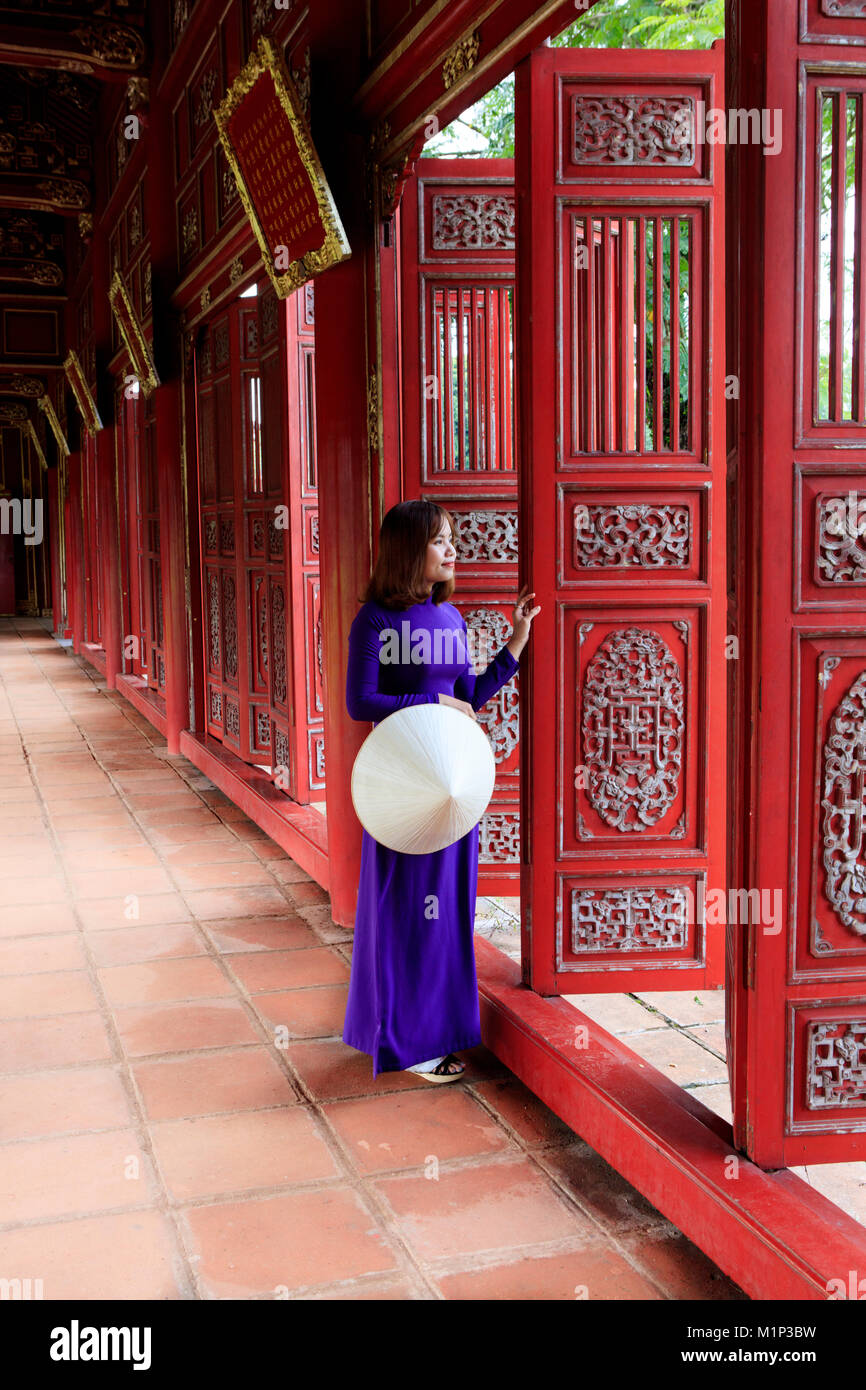 Une femme dans une robe traditionnelle Ao Dai et non la chapeau conique dans la Cité pourpre interdite de Hue, l'UNESCO, Thua Thien Hue, Vietnam, l'Indochine, l'Asie Banque D'Images