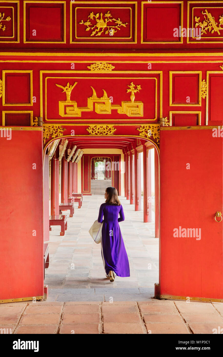 Une femme dans une robe traditionnelle Ao Dai dans la Cité pourpre interdite de Hue, l'UNESCO, Thua Thien Hue, Vietnam, Indochine, Asie du Sud-Est, l'Asie Banque D'Images