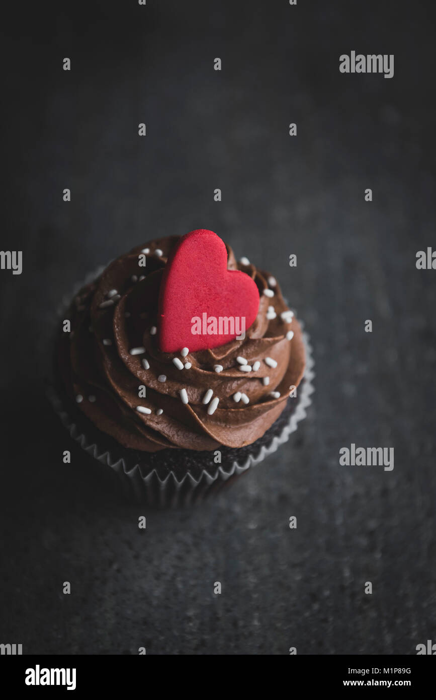 Cup Cake romantique avec crème au chocolat servi sur le fond sombre,carte greating, card, Banque D'Images