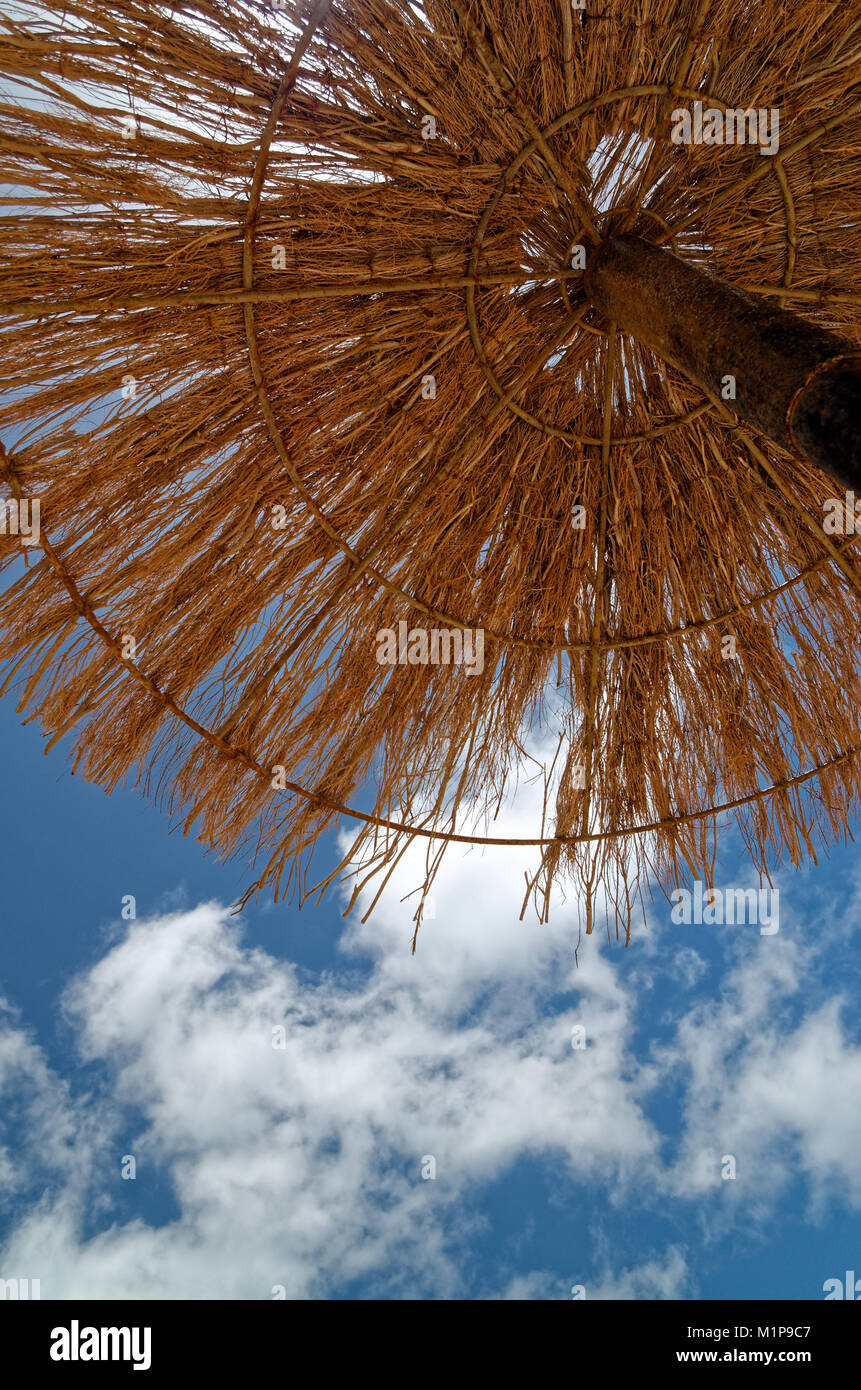 Jusqu'à la paille dans le parasol et le bleu du ciel. Cette scène a été prise sur la plage de sable sur le Sal au Cap Vert. Banque D'Images