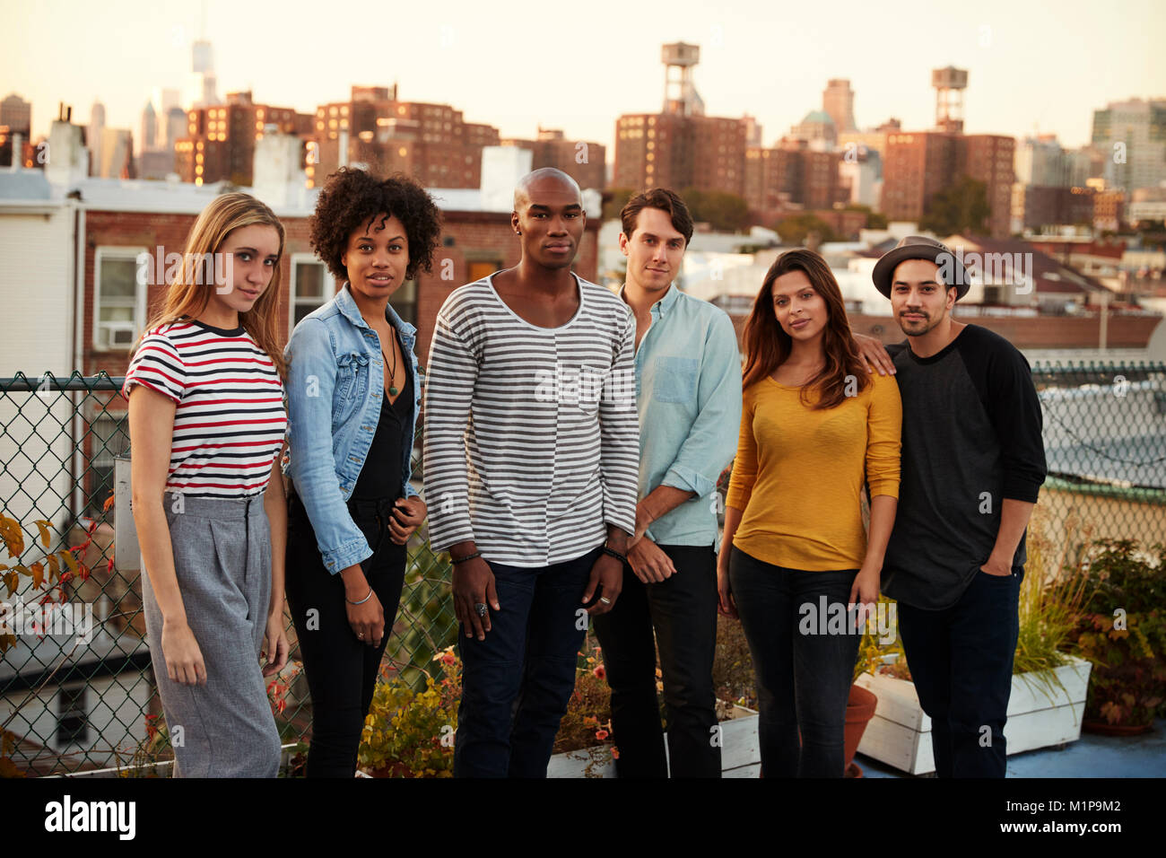 Six amis adultes debout ensemble sur un toit de Brooklyn Banque D'Images