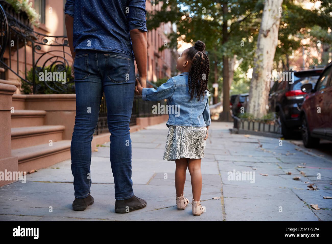 Père et fille de prendre une marche dans la rue, vue de dos Banque D'Images