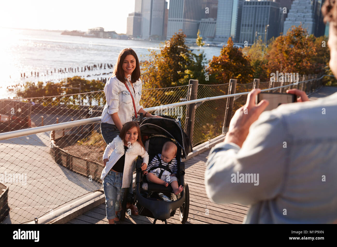 Jeune famille avec deux filles de prendre une photo sur la passerelle Banque D'Images