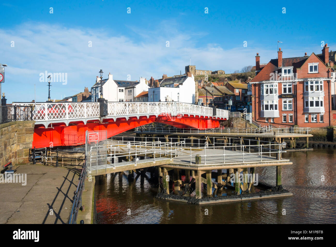 Pont tournant de Whitby rouge peint de couleurs vives, vue depuis le côté ouest de la rivière Esk avec guide des structures pour éviter les dommages par les bateaux de passage Banque D'Images
