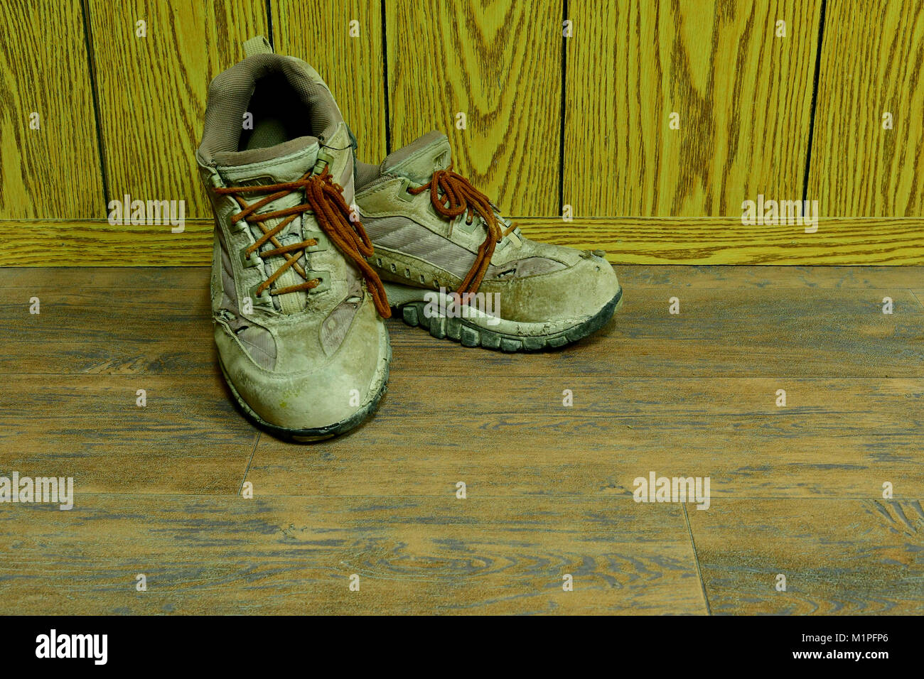 Sale vieux chaussures de sécurité vers le bas sur le plancher en bois Banque D'Images