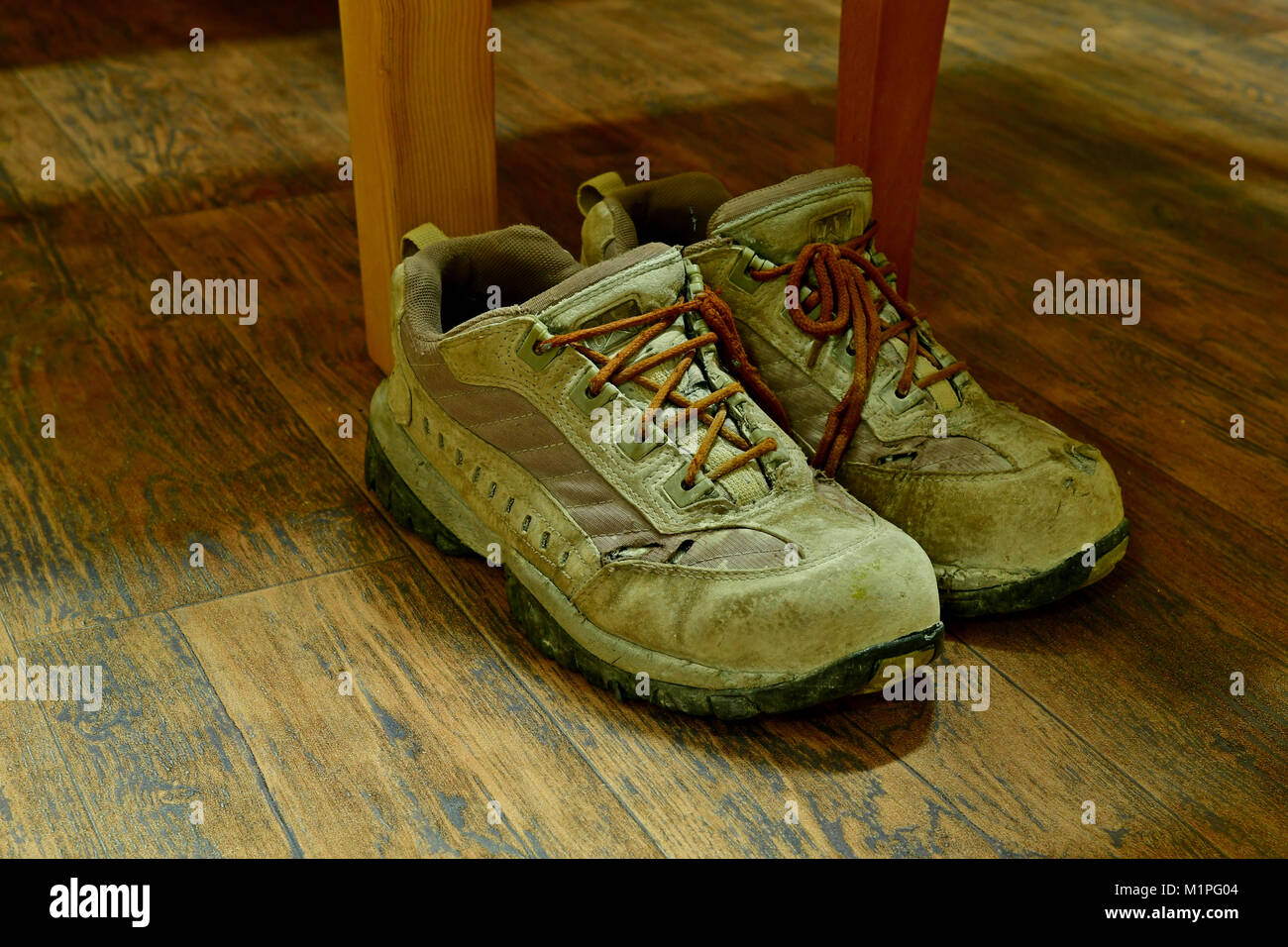 Sale vieux chaussures de sécurité vers le bas sur le plancher en bois Banque D'Images