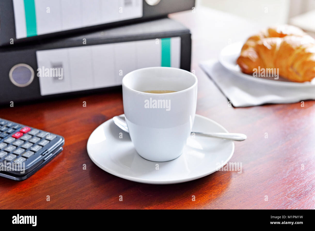 Scène à un petit déjeuner de travail. Arrière-plan de bureau avec tasse de café, croissant, calculatrice et fichiers. Pause de travail. Banque D'Images