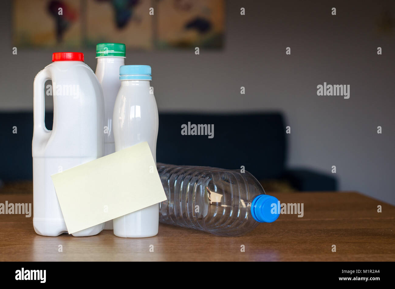 Les bouteilles en plastique avec du papier autocollant sans texte debout sur la table en bois à la lumière du jour avec de la terre la carte floue sur l'arrière-plan Banque D'Images