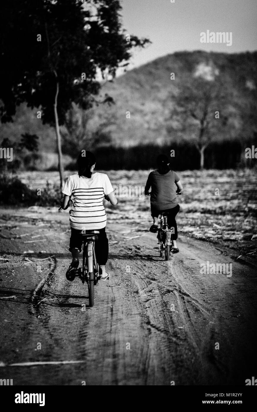 Les enfants faire du vélo dans les zones rurales de la Thaïlande. Banque D'Images