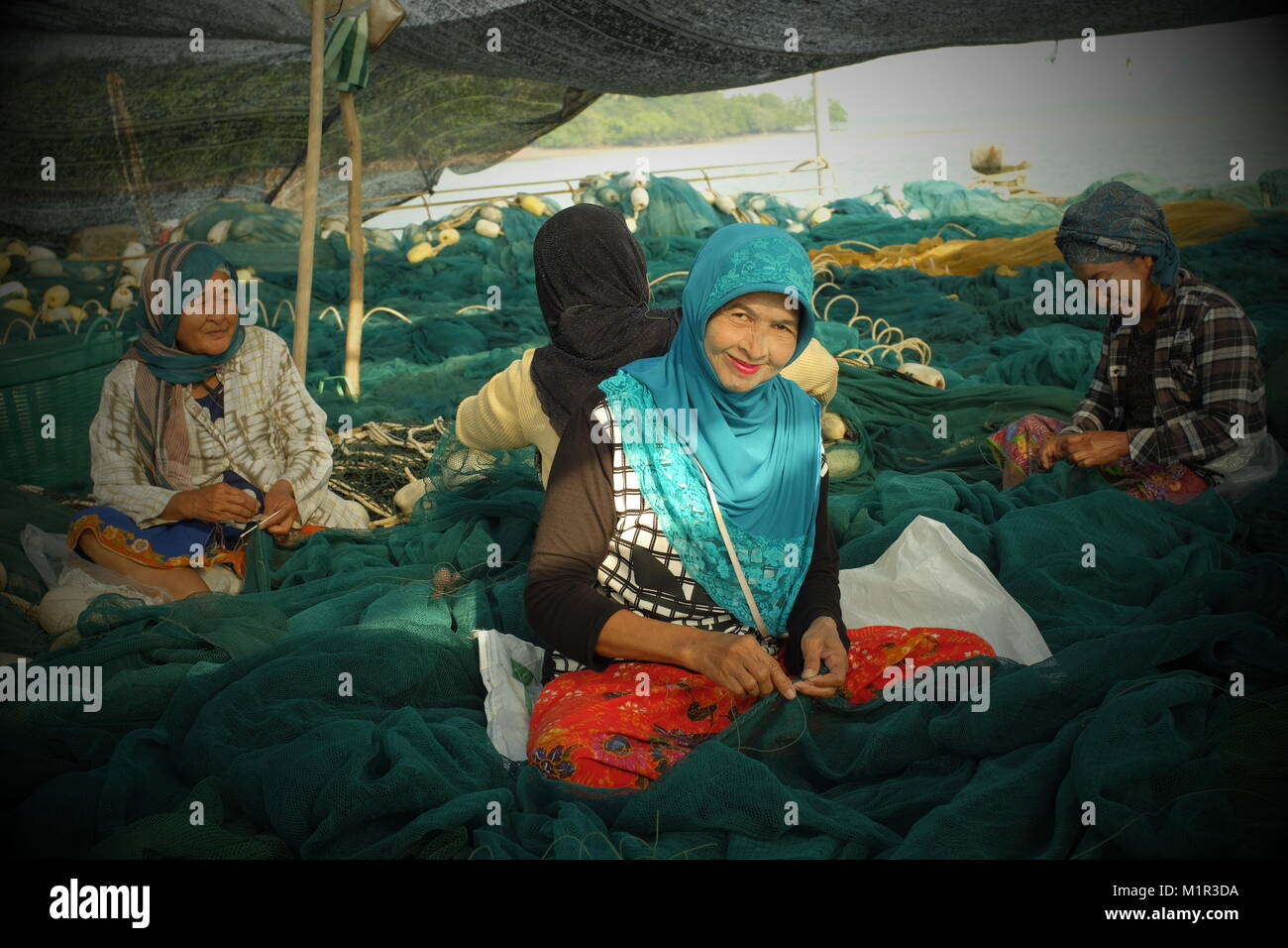 Les femmes musulmanes locales tissent le filet de pêche dans la région de koh Yao Yai, une île thaïlandaise dans la mer d'Andaman. 20-Jan-2018 Banque D'Images