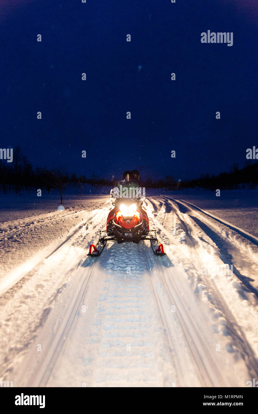 Skibotn, la Norvège. La motoneige en action dans la nuit. Banque D'Images