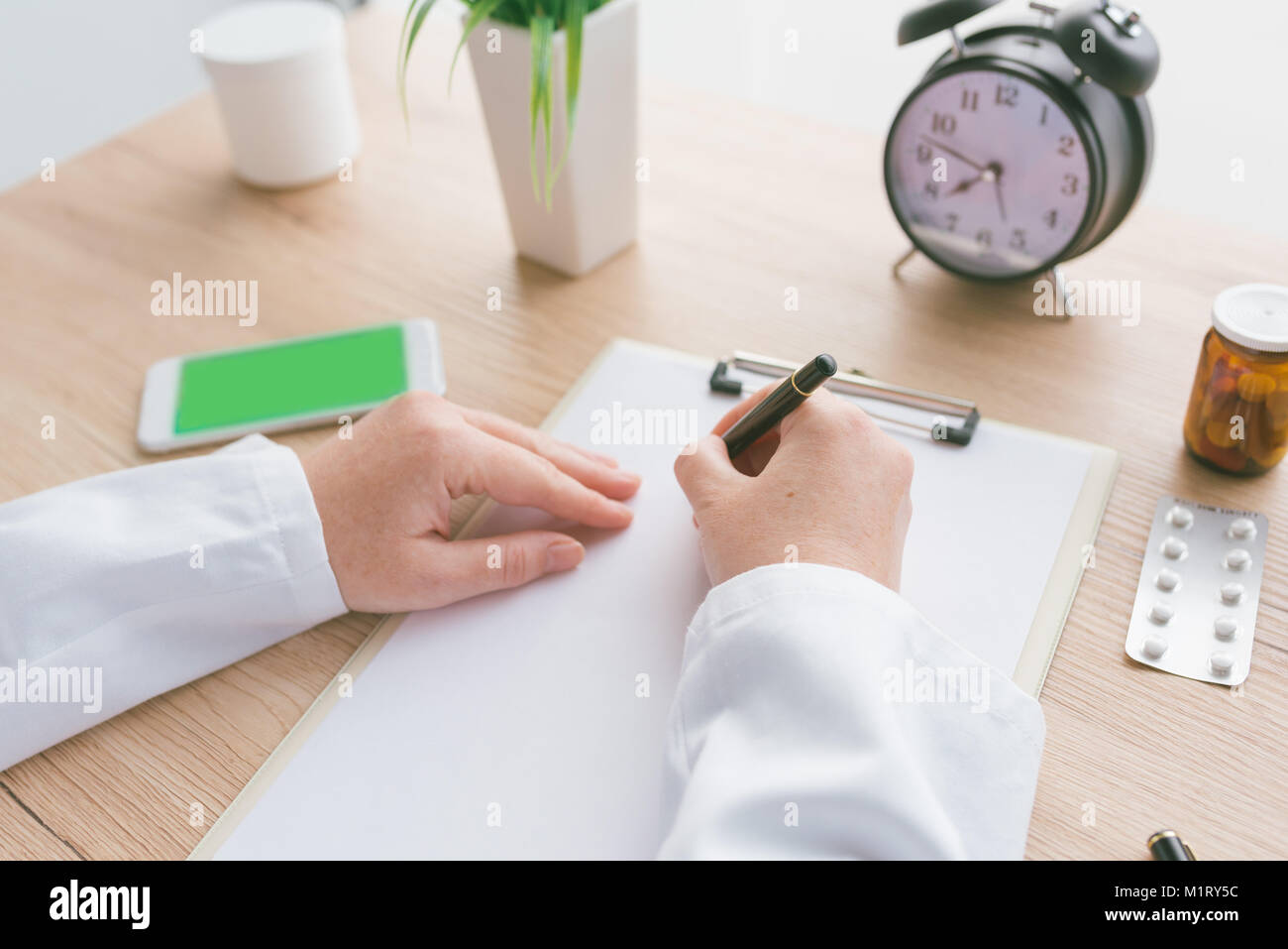 Femme médecin à écrire des notes, les antécédents médicaux du patient ou la médecine prescription sur presse-papiers papier pendant l'examen médical à l'hôpital office Banque D'Images