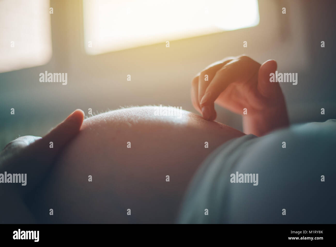 Femme enceinte ventre câlins dans la chambre à la maison juste avant le travail et l'accouchement, selective focus Banque D'Images