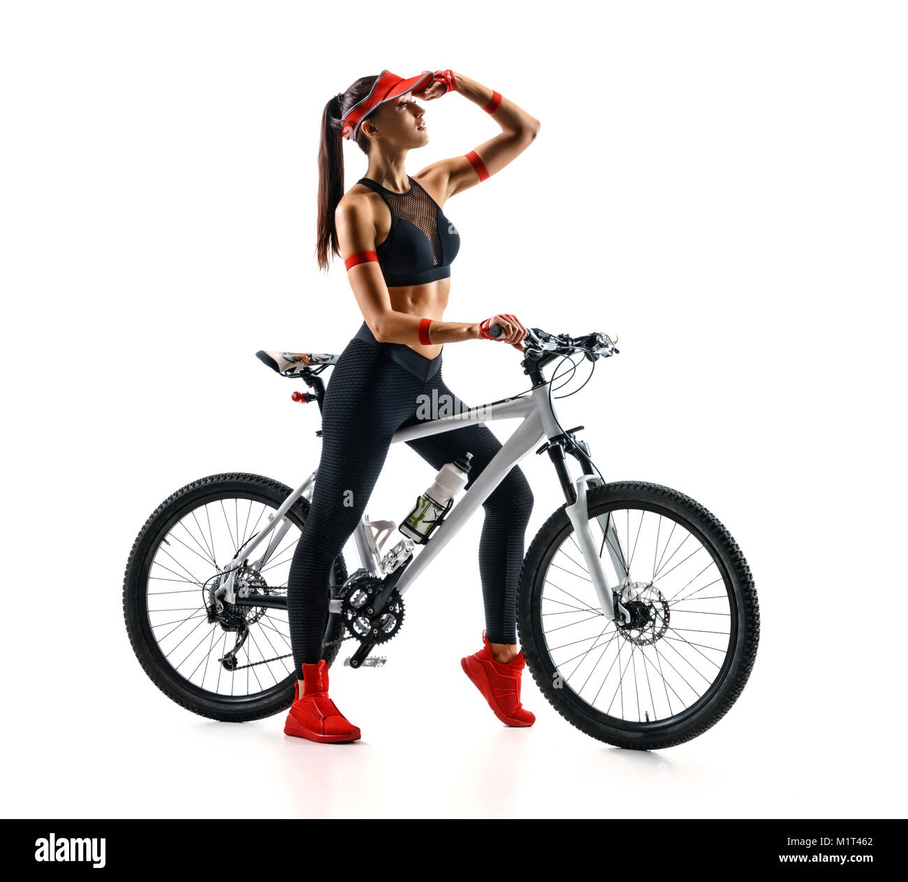 Femme sportive avec le vélo à la recherche dans la distance en silhouette sur fond blanc. Sport et mode de vie sain Banque D'Images