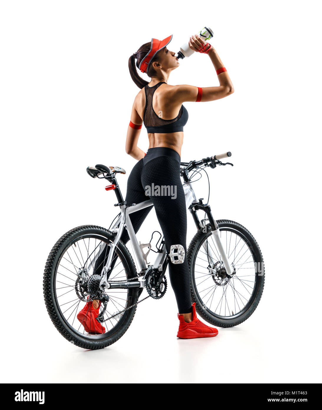 Cycliste avec fille de l'eau potable un vélo en silhouette sur fond blanc. Vue arrière. Sport et mode de vie sain Banque D'Images