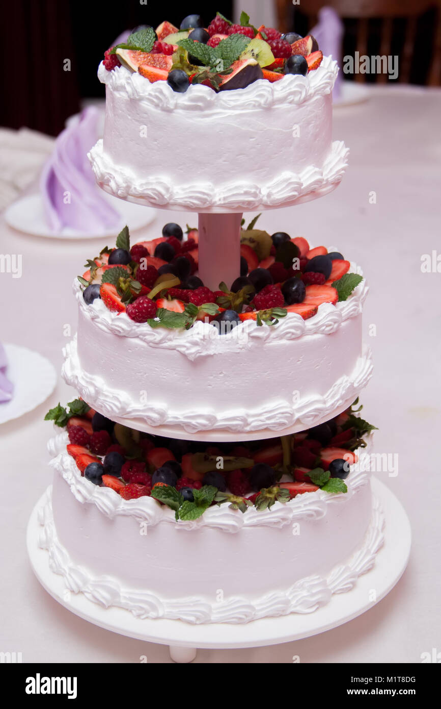 Gâteau de mariage décoré de fleurs et de fruits rouges Banque D'Images