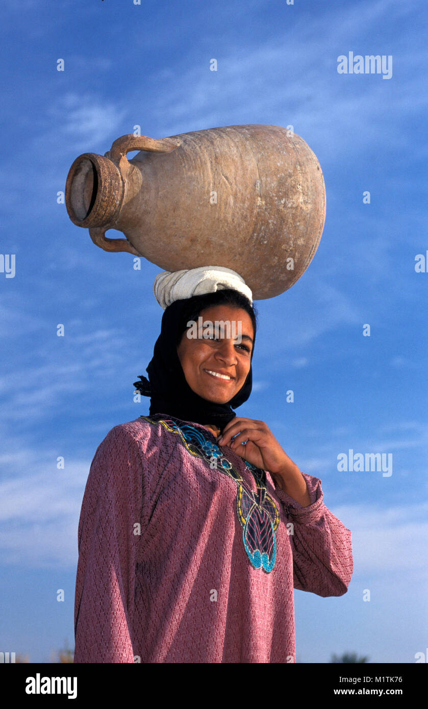 L'Egypte, Louxor. Banque de l'Ouest. Femme transportant jar pour recueillir l'eau. Banque D'Images