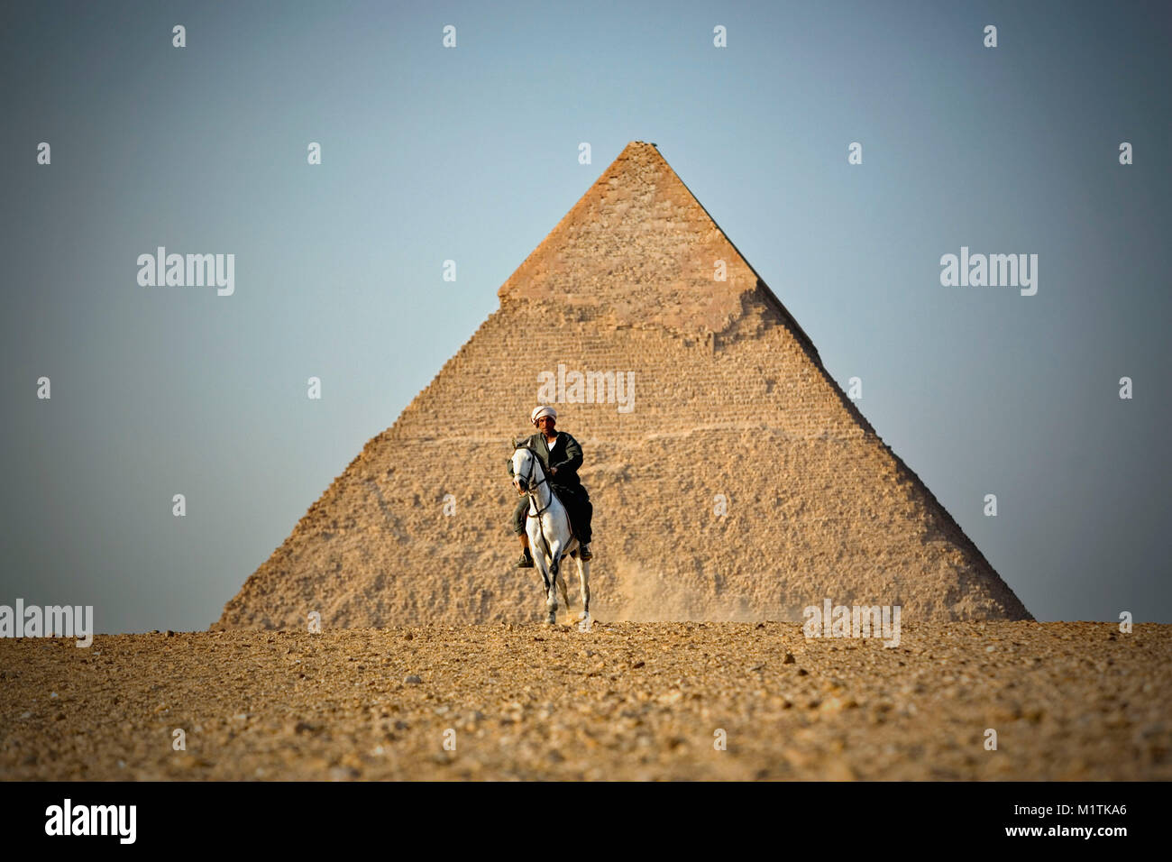 L'Egypte, Le Caire. Gizeh ou Giza. Pyramides. Man riding Horse au les pyramides de Gizeh. L'Unesco, site du patrimoine mondial. Banque D'Images