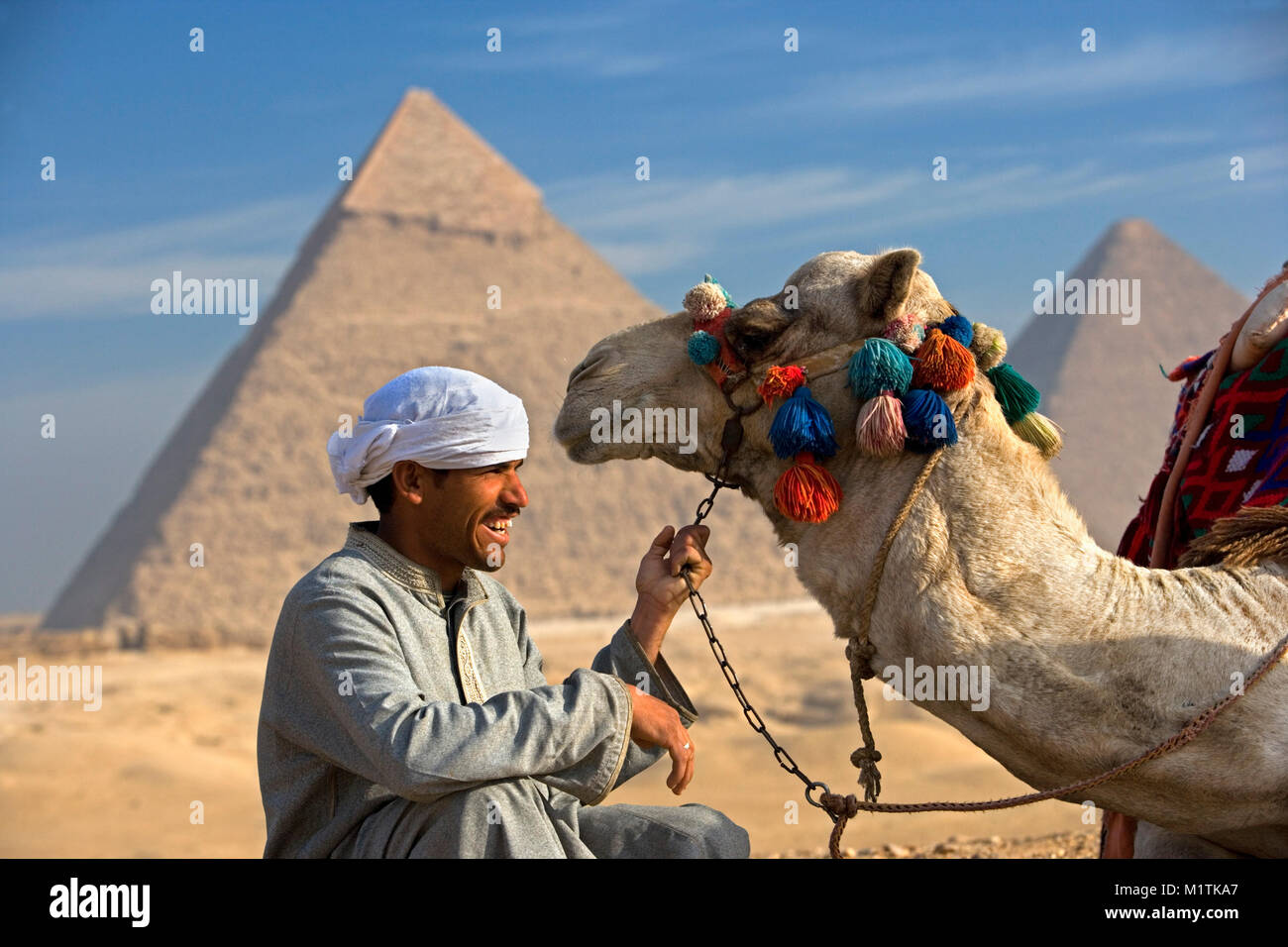 L'Egypte, Le Caire. Pyramides de Gizeh ou Giza. L'homme, chamelier et son chameau dans le désert près de pyramides. L'Unesco, site du patrimoine mondial. Banque D'Images