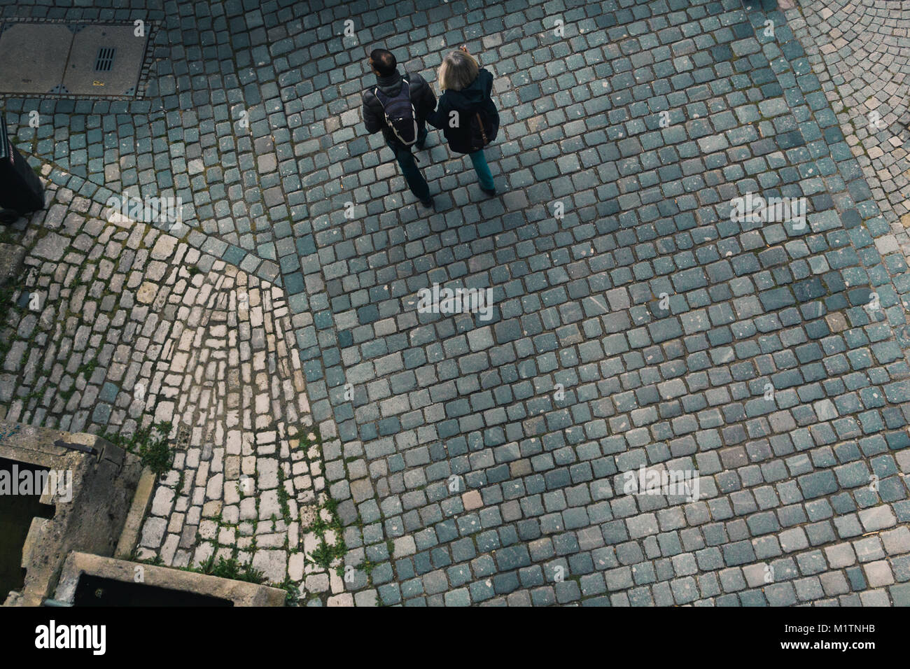 Vue vers le bas d'un couple en train de marcher sur le sol de pierre medivel de la ville allemande de Rottenburg. Banque D'Images