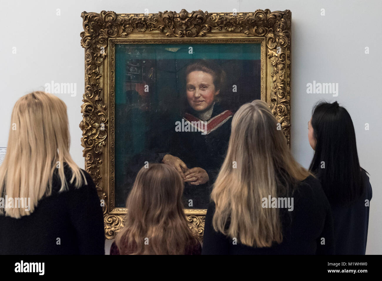 Londres, Royaume-Uni. 2e Février, 2018. Les membres du personnel, rejoint par Stella Cartwright, âgés de 9, voir un portrait de Millicent Fawcett, par Annie Swynnerton, sur l'affichage à la Tate Britain pour marquer le centenaire de la le droit de vote des femmes, telle que voulue par la Loi sur la représentation du peuple. Millicent Fawcett a été une figure de proue dans le mouvement suffragiste, campagne pour le droit de vote pour les femmes au Royaume-Uni, alors qu'Annie Swynnerton est l'une des premières femmes élues d'être membre de l'Académie Royale des Arts du Canada Crédit : Stephen Chung/Alamy Live News Banque D'Images