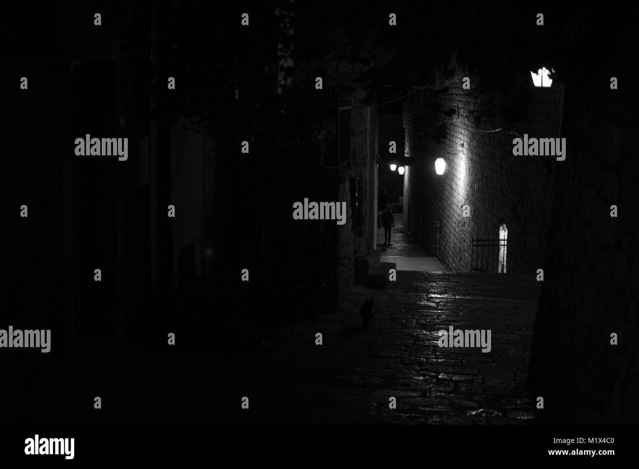 Ruelle pittoresque allumé avec silhouettes de personnes à Dubrovnik, Croatie Banque D'Images