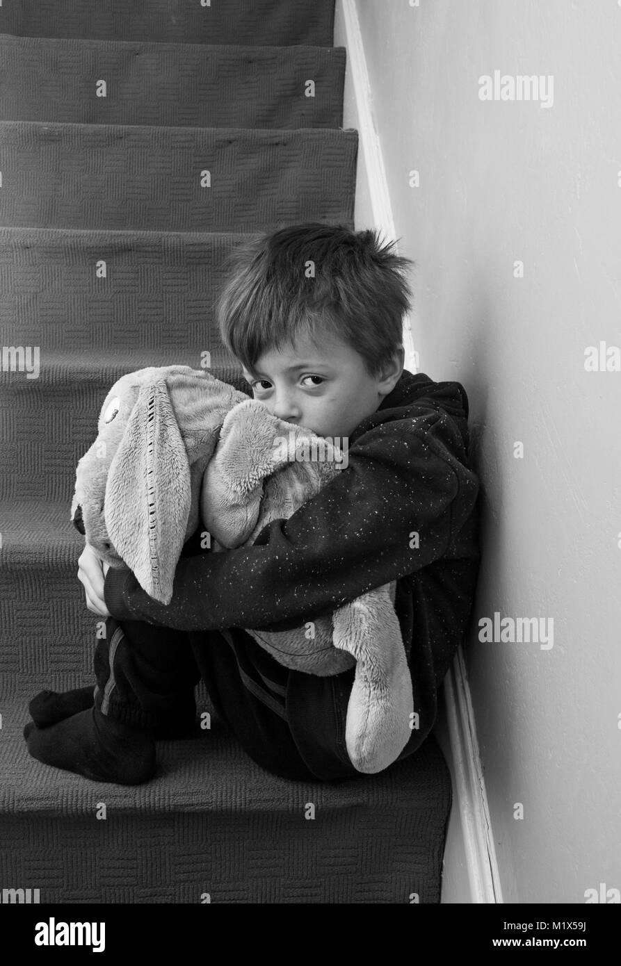 Sentiment d'abandon de l'enfant solitaire assis sur l'escalier. Banque D'Images
