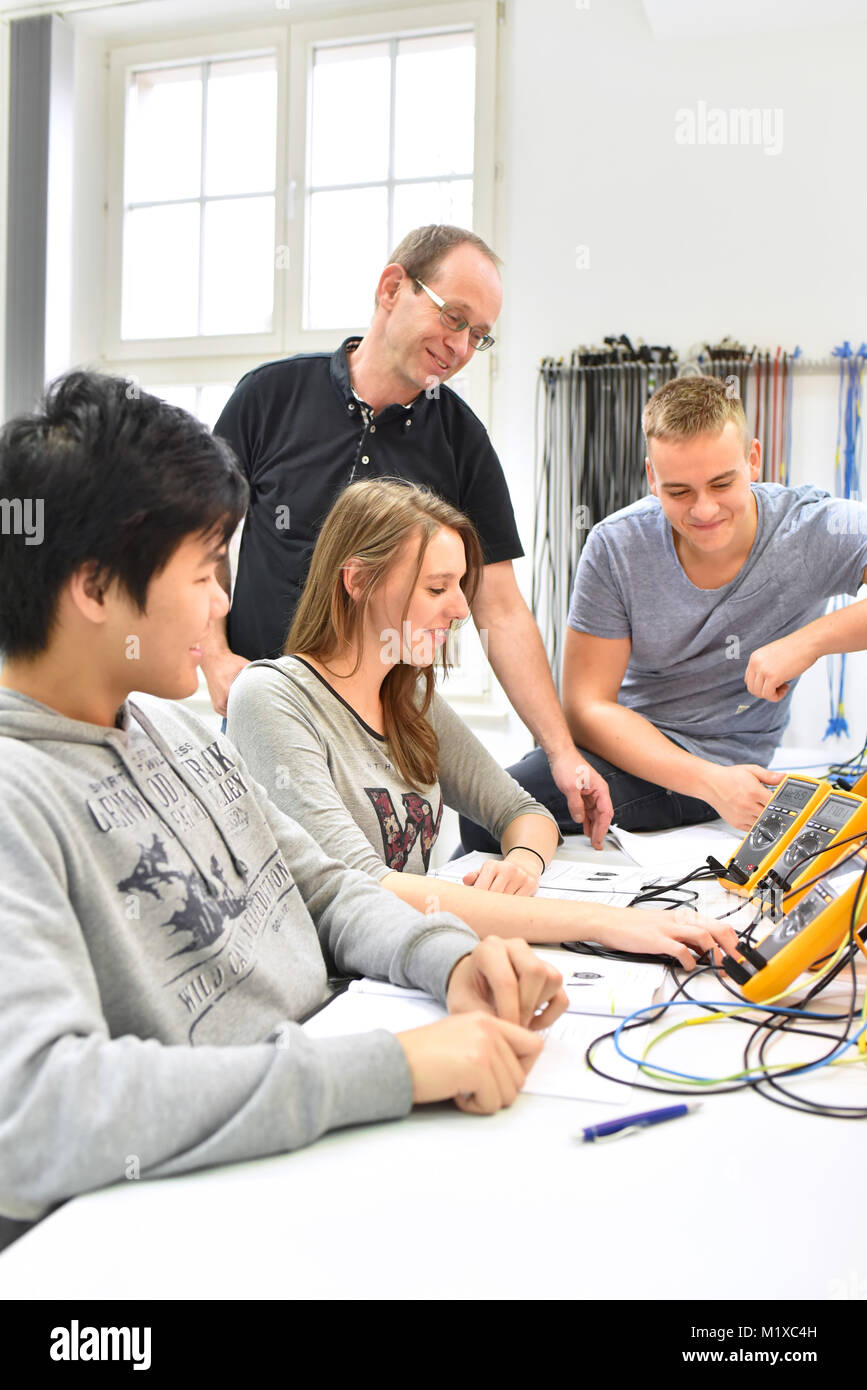 Formation professionnelle dans l'industrie : de jeunes apprentis et formateurs en classe Banque D'Images