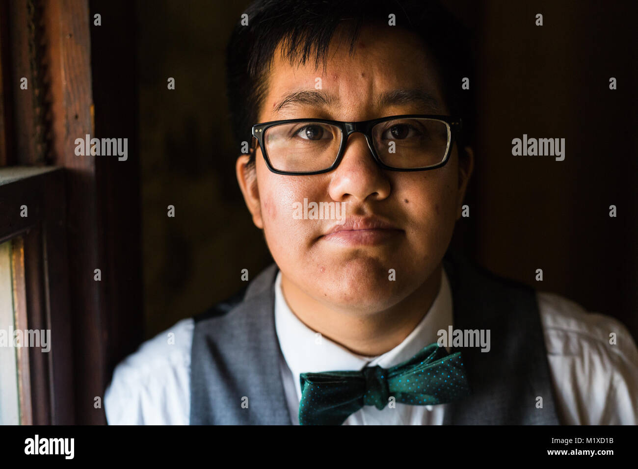 Jeune homme transgenres dans l'Habillement formel pose dans un emplacement grungy urban Banque D'Images