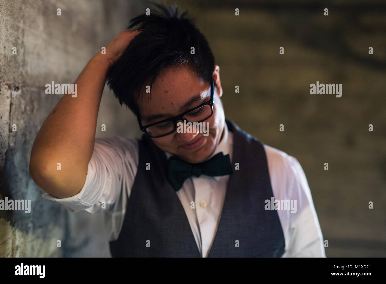 Jeune homme transgenres dans l'Habillement formel pose dans un emplacement grungy urban Banque D'Images