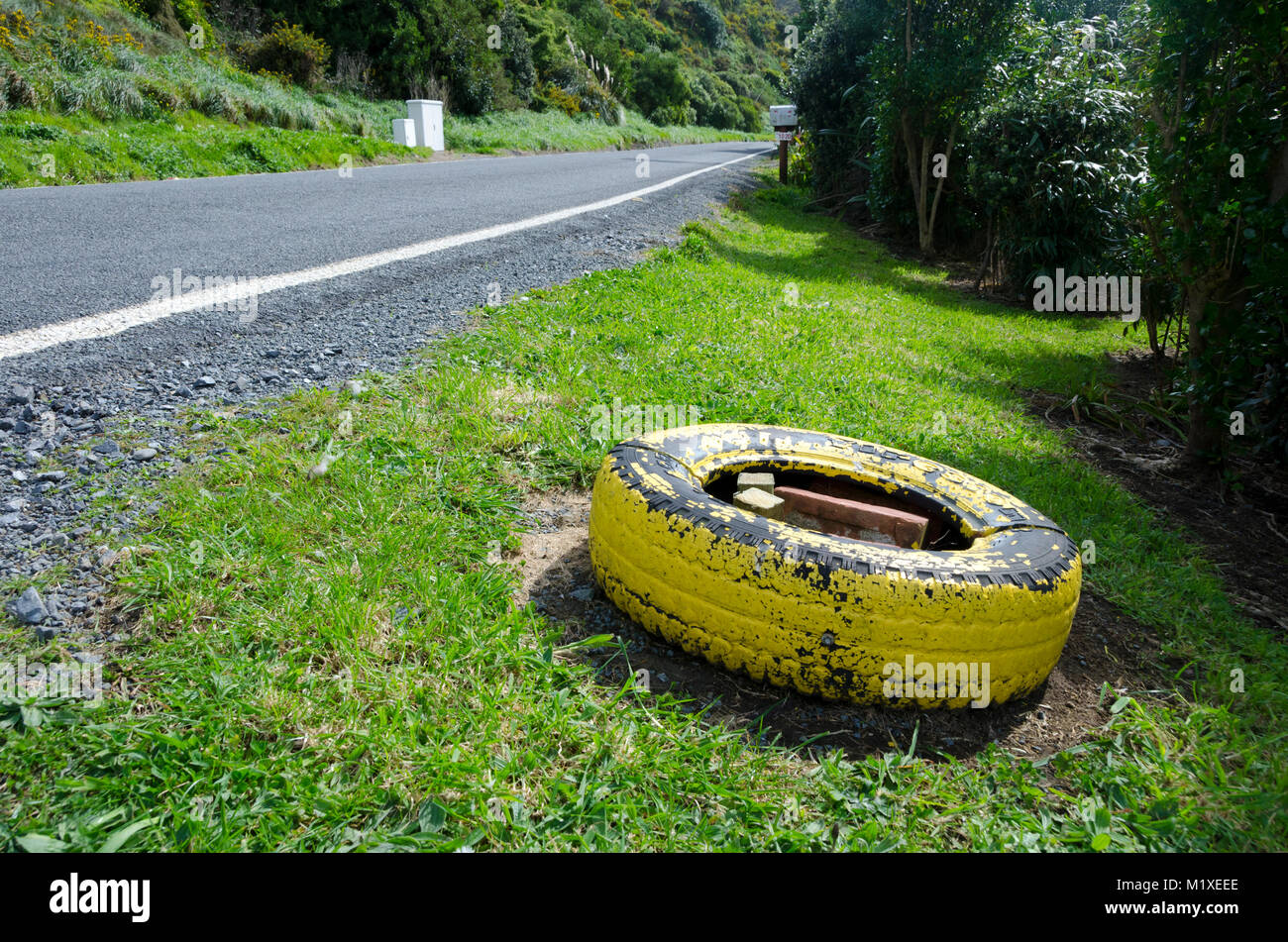 Pneu jaune à côté de la route, Makara Beach, Wellington, Nouvelle-Zélande Banque D'Images