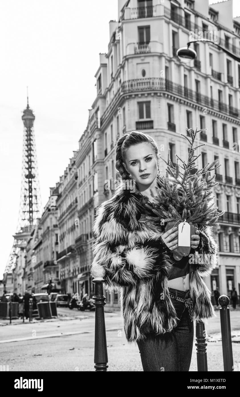 Extrêmement chaud d'hiver à la mode à Paris. Portrait de femme moderne avec arbre de Noël dans Paris, France recherche dans la distance Banque D'Images