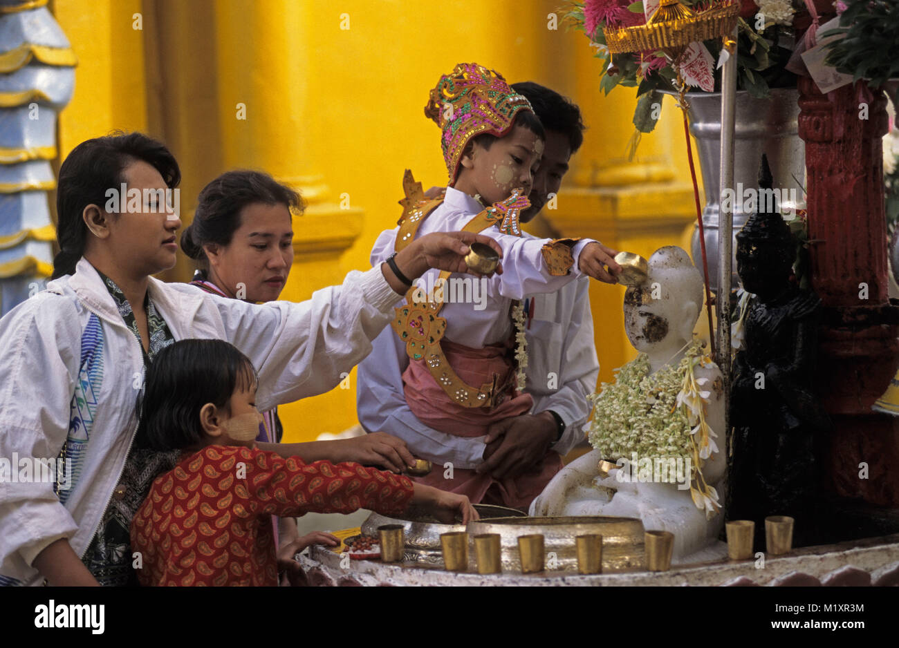 Myanmar (Birmanie). Yangon (Rangoon). La Pagode Schwedagon. Boy offre en tant que novice au cours de shin-puy garçon cérémonie avec ses parents et sa famille. Banque D'Images