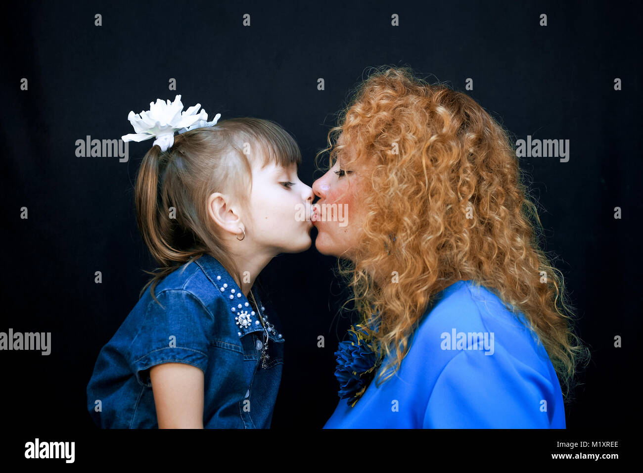 Sur fond noir, mère et fille s'embrassant. Ils s'aiment et sont très heureux. Banque D'Images