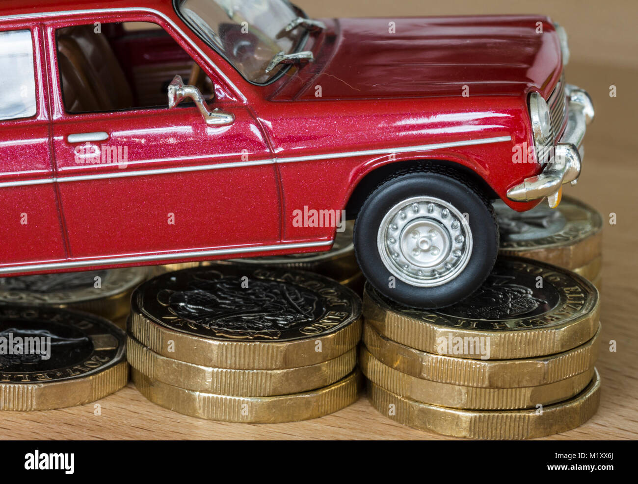 Concept photo pour l'augmentation du coût de l'automobile, modèle voiture sur pièces livre Banque D'Images