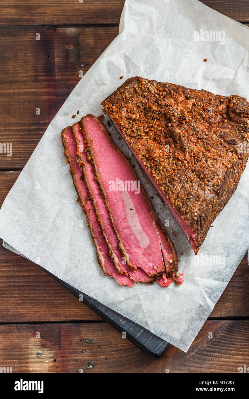 Tranches de pastrami de boeuf sur planche de bois Banque D'Images