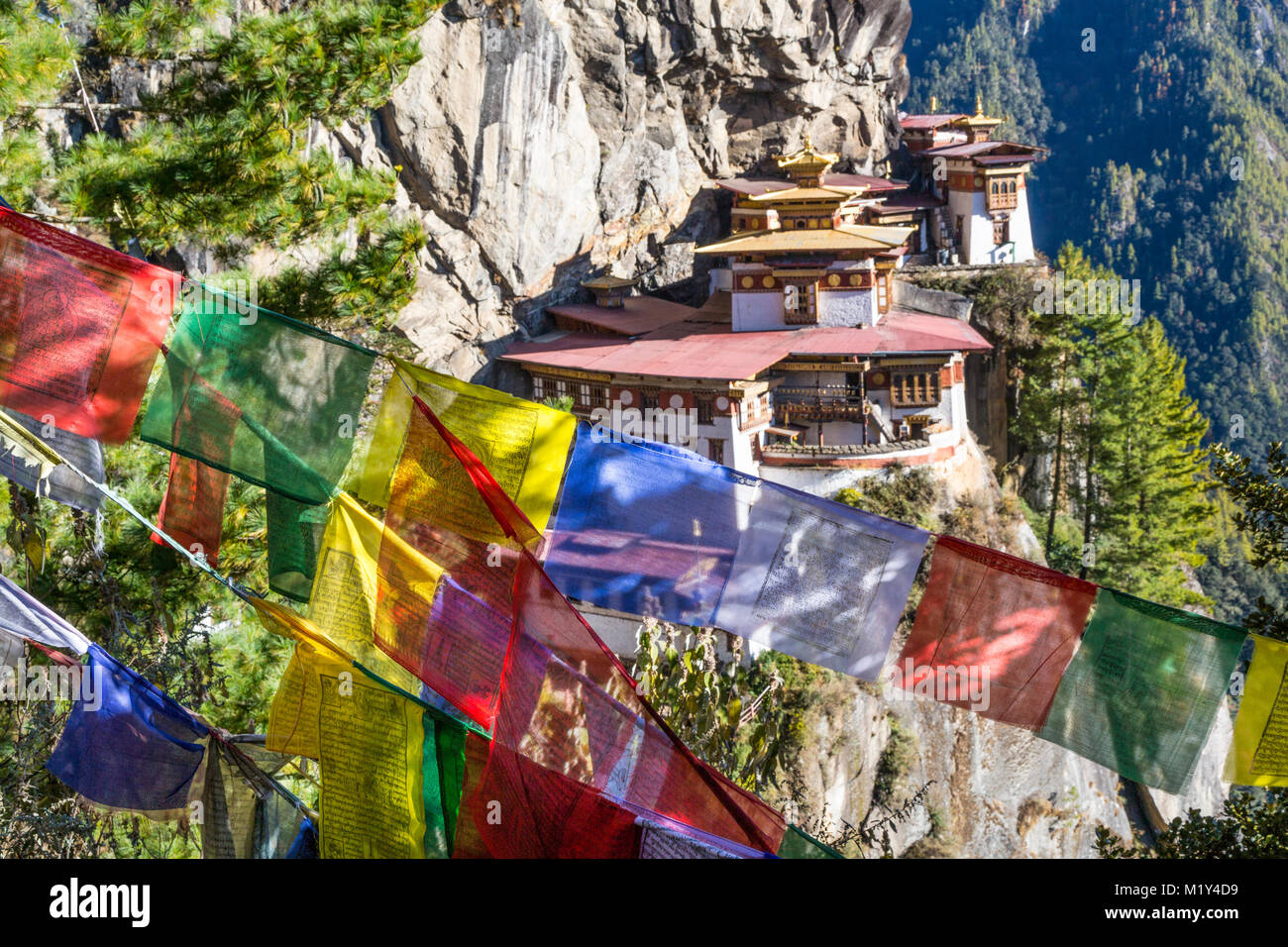 Paro, Bhoutan. Le nid du tigre monastère, les drapeaux de prières en premier plan. Banque D'Images