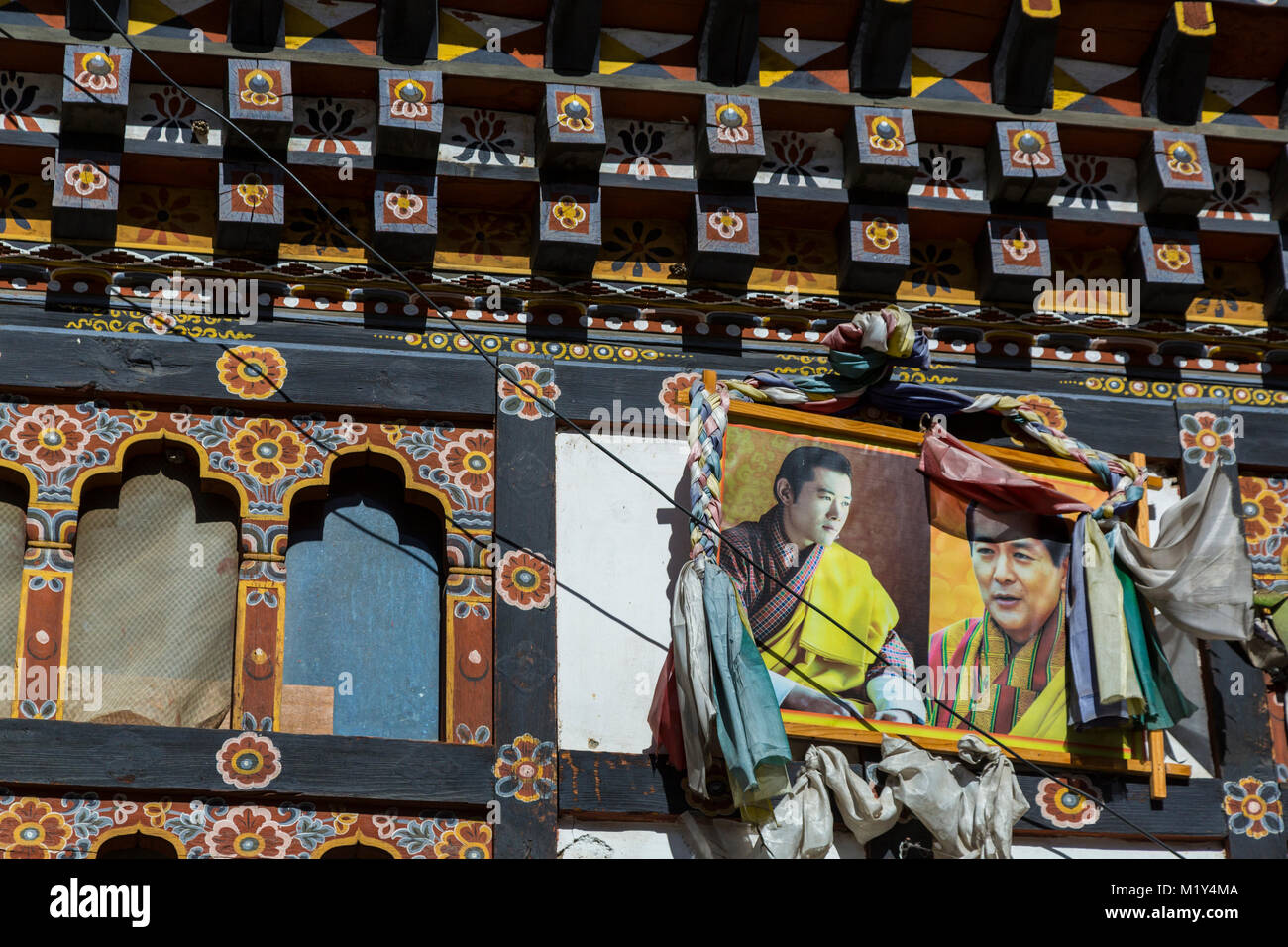 Paro, Bhoutan. Photographies du roi sur une devanture de magasin sur la rue principale de Paro. Banque D'Images