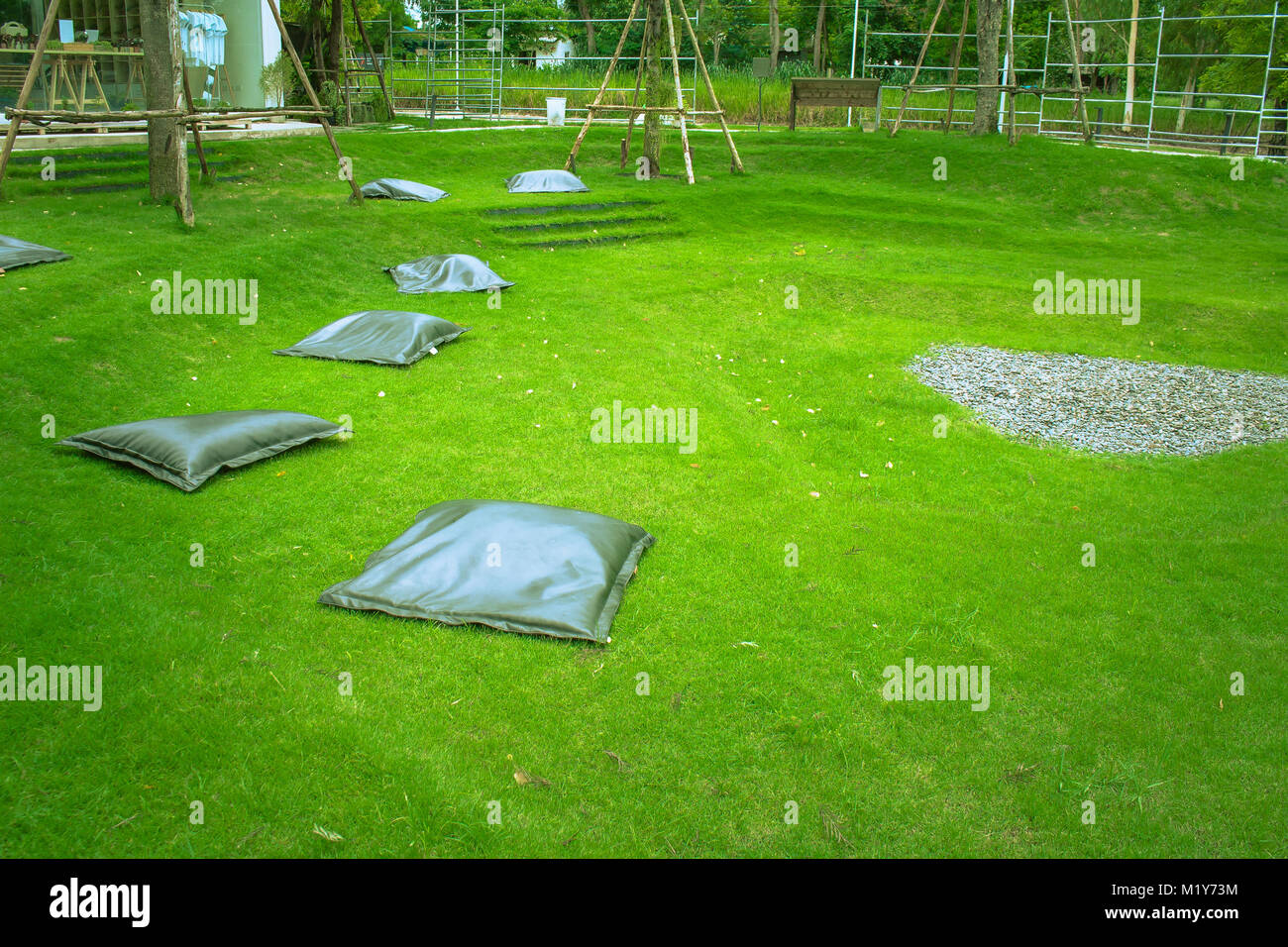 De nombreux paramètre oreiller noir sur l'herbe verte au jardin extérieur, pour le repos et détente. Banque D'Images