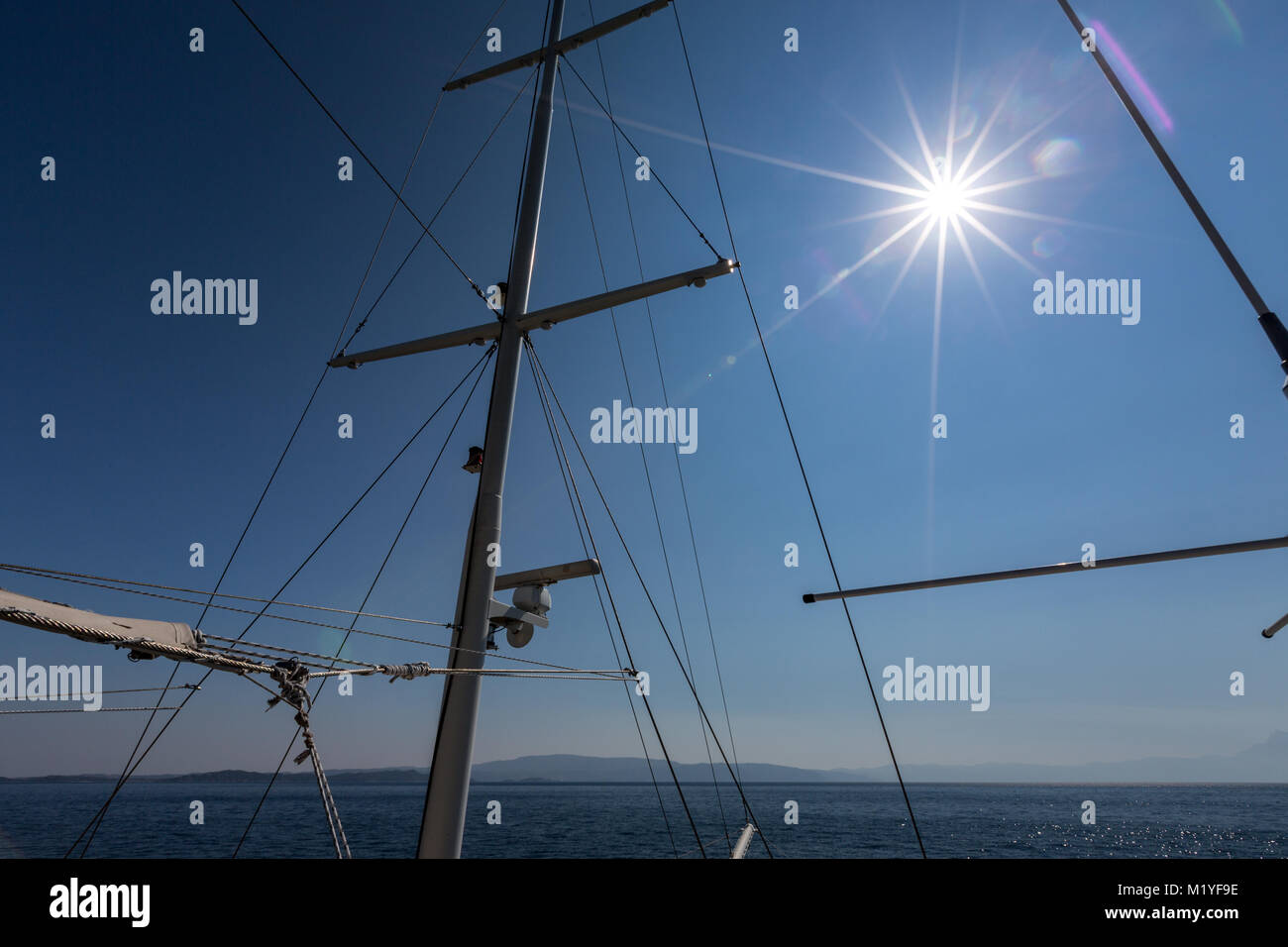 Mât et gréement d'un navire touristique en Grèce plus de ciel bleu avec des torches Sun Banque D'Images