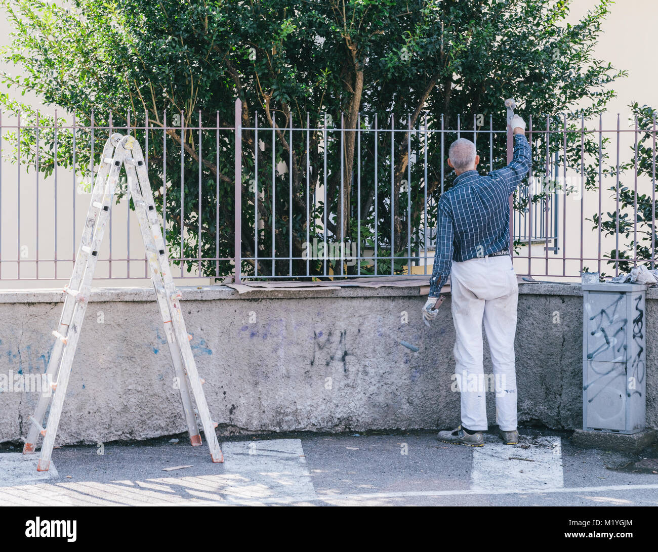 Homme plus âgé une clôture peinture Banque D'Images