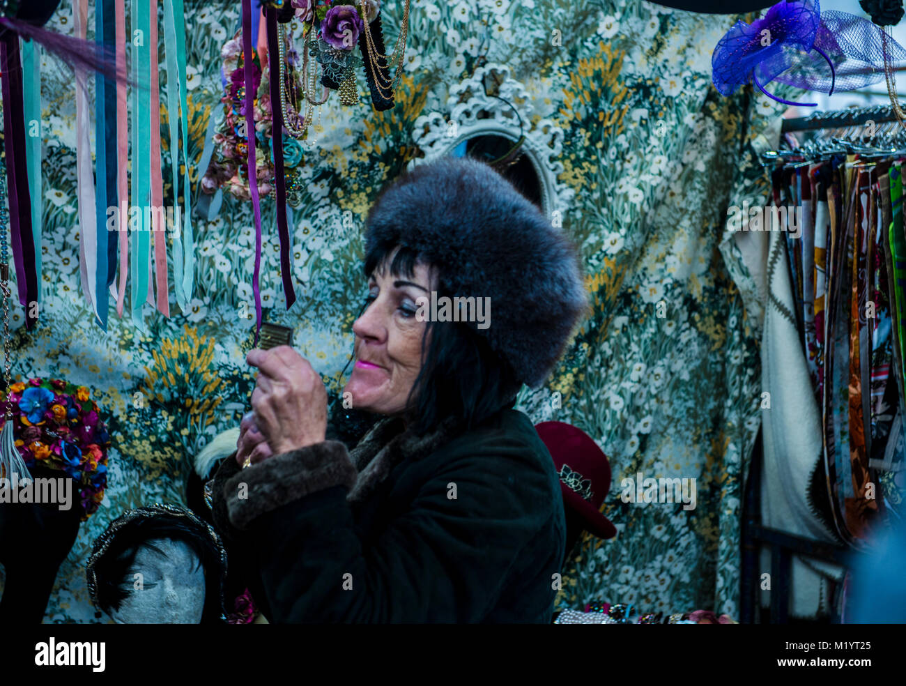 Woman in fur hat sur market stall, Portobello, Londres, Angleterre Banque D'Images