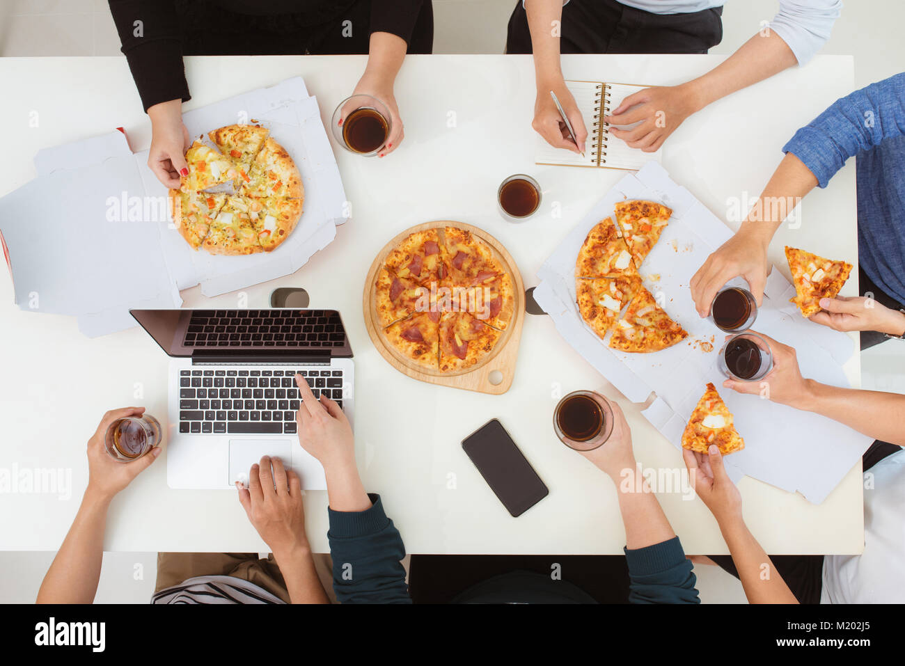 Le déjeuner et le peuple concept. Happy business team eating pizza in office Banque D'Images