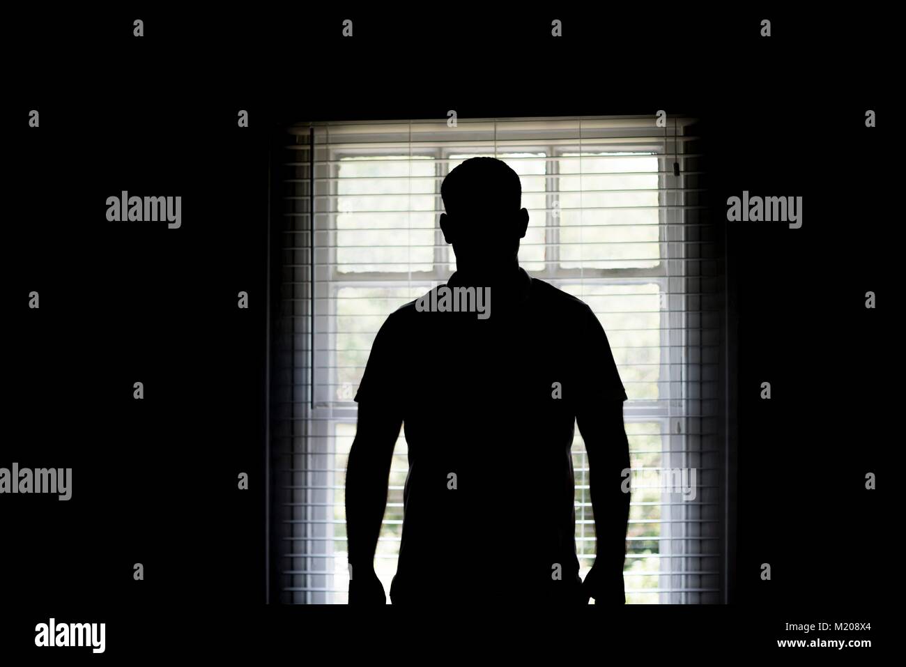 Silhouette d'un homme par une fenêtre. Banque D'Images