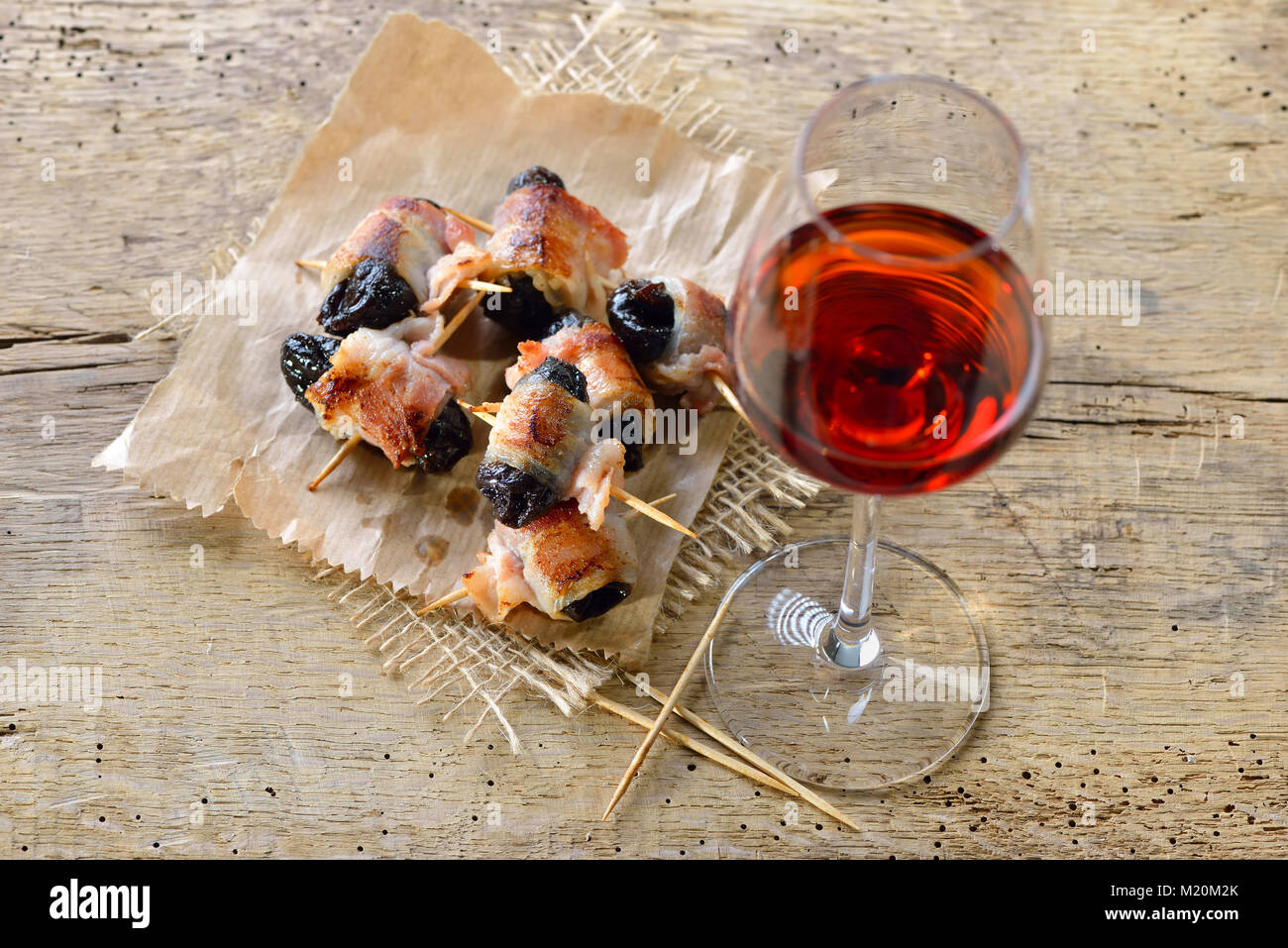 De délicieux tapas espagnol : pruneaux enrobé de bacon frit servi avec du vin portugais Banque D'Images