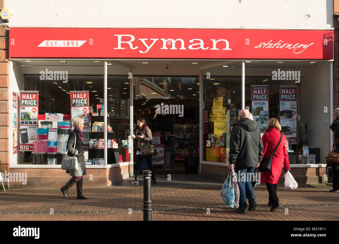 Les gens en passant devant la boutique avant de Ryman papeterie à Carlisle, Cumbria, England, UK Banque D'Images