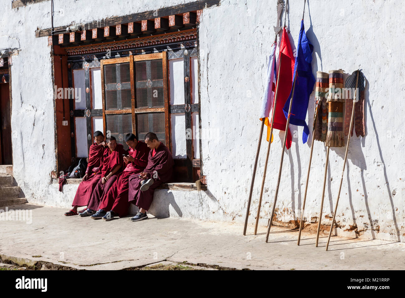 Prakhar Lhakhang, Bumthang, Bhoutan. Les jeunes moines à la recherche à leur téléphone cellulaire. Banque D'Images