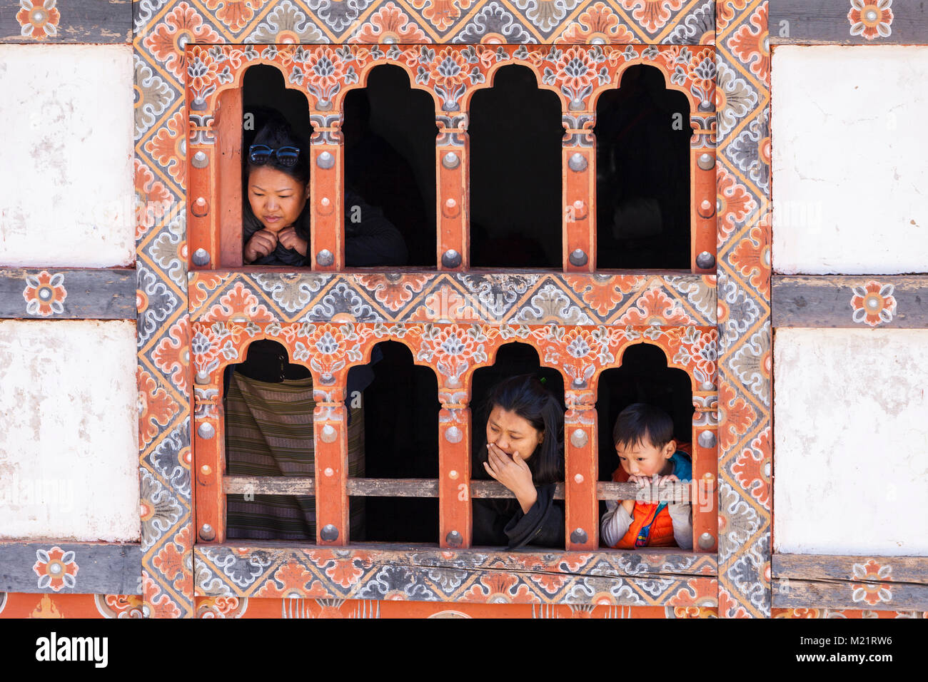 Prakhar Lhakhang, Bumthang, Bhoutan. Les femmes et le garçon dans la fenêtre du monastère. Banque D'Images