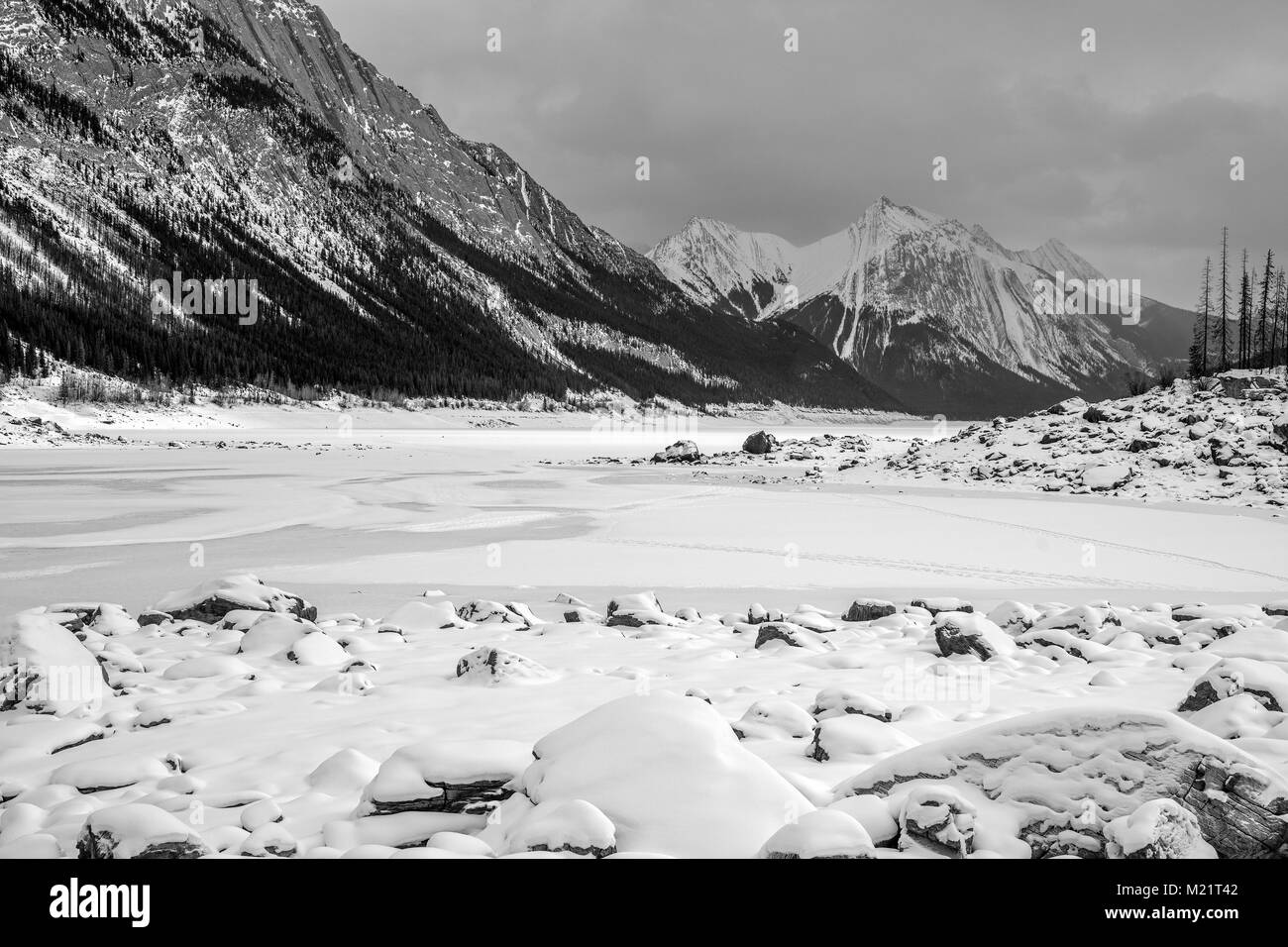 Le format panorama photo d'un paysage hivernal de la médecine lac gelé entouré par les rocheuses canadiennes dans le parc national de Banff, Alberta, Canada Banque D'Images