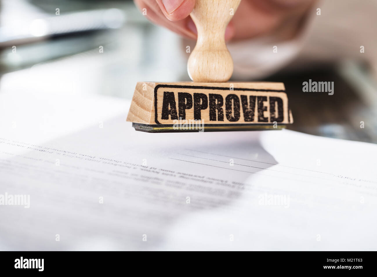 Close-up of a person holding a approuvé le Document sur l'horodateur sur Desk In Office Banque D'Images
